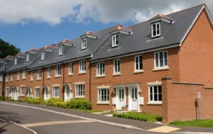 Row-of-modern-red-brick-houses-with-paved-driveways-and-lush-landscaping-focus-on-council-tax-premiums