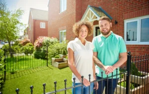 A-happy-couple-in-front-of-their-new-home-representing-Landlord-Guaranteed-Rent