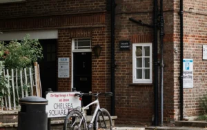 A-sheltered-housing-unit-featuring-a-brick-building-with-clear-signage-and-private-roadway-access
