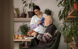 Residential-Care-support-worker-assisting-an-elderly-man-indoors