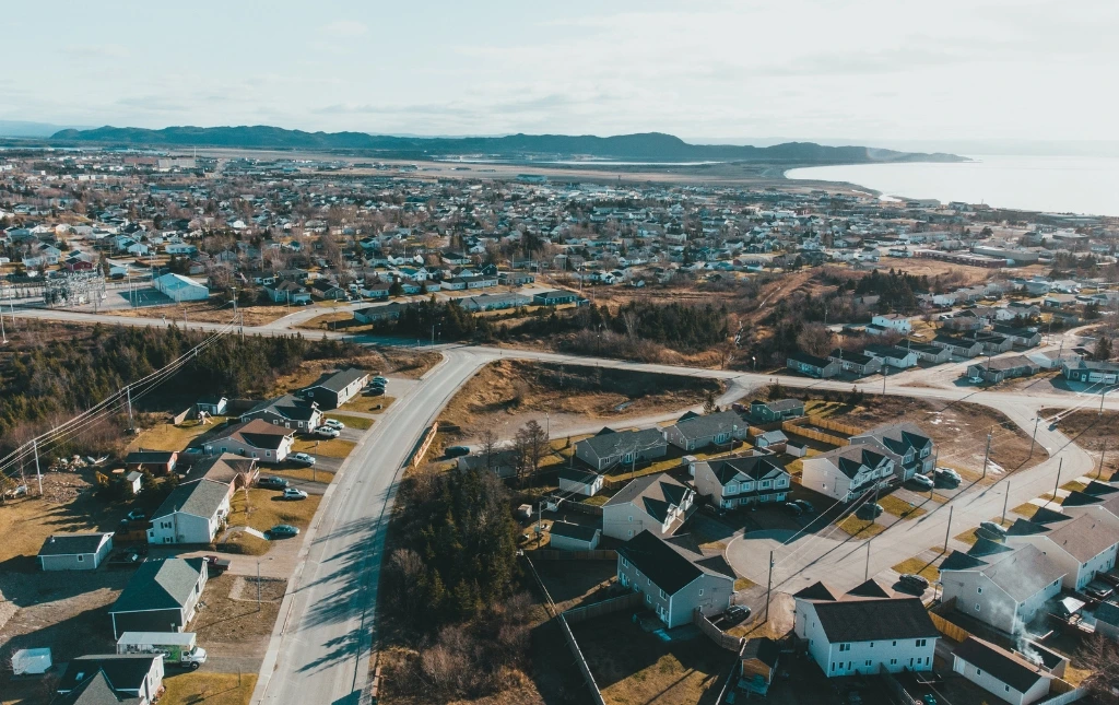 Aerial-view-of-a-residential-area-showing-houses-and-roads-with-mountains-in-the-distance-under-clear-sky-and-sunshine-strategic-location-selection