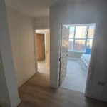 A-hallway-with-two-doors-leading-to-rooms-and-a-view-into-a-bedroom