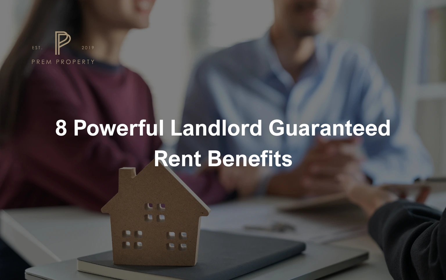 A-model-house-next-to-a-table-representing-Landlord-Guaranteed-Rent