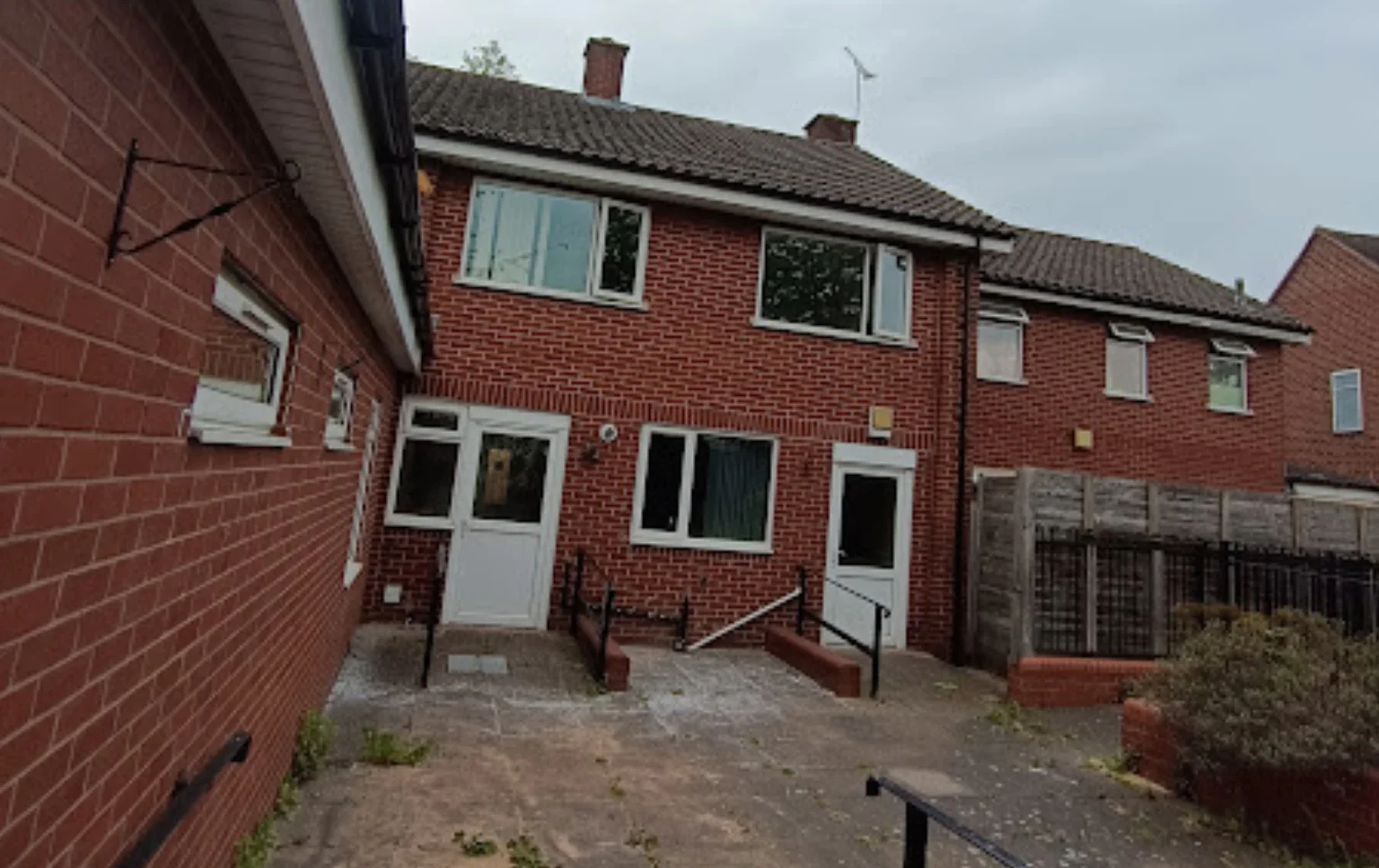 Packington-Ave-6-Bed-C2-exterior-view-showing-the-rear-of-the-brick-built-residential-care-property-with-access-doors-and-courtyard-area
